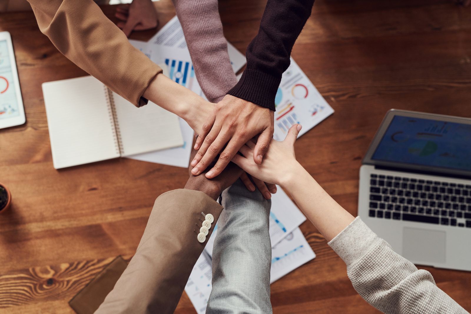 Externalisation marketing : mains réunies d’une équipe dédiée autour d’un bureau